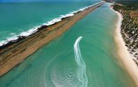 Vista panorâmica aérea do geossítio Recife de Arenito de Muro Alto que durante a maré baixa forma uma grande piscina entre a linha de praia e o recife. Foto: https://www.dicasportodegalinhas.com.br/2020/03/23/titulo-do-post4/. Acesso em 17/08/21.